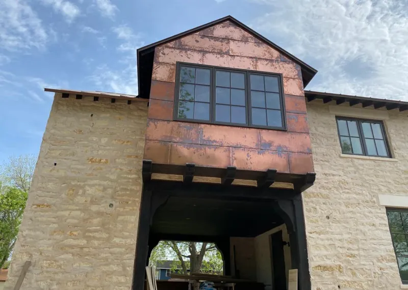 Copper metal panel facade on a stone building for Roof Repair in Jarrell