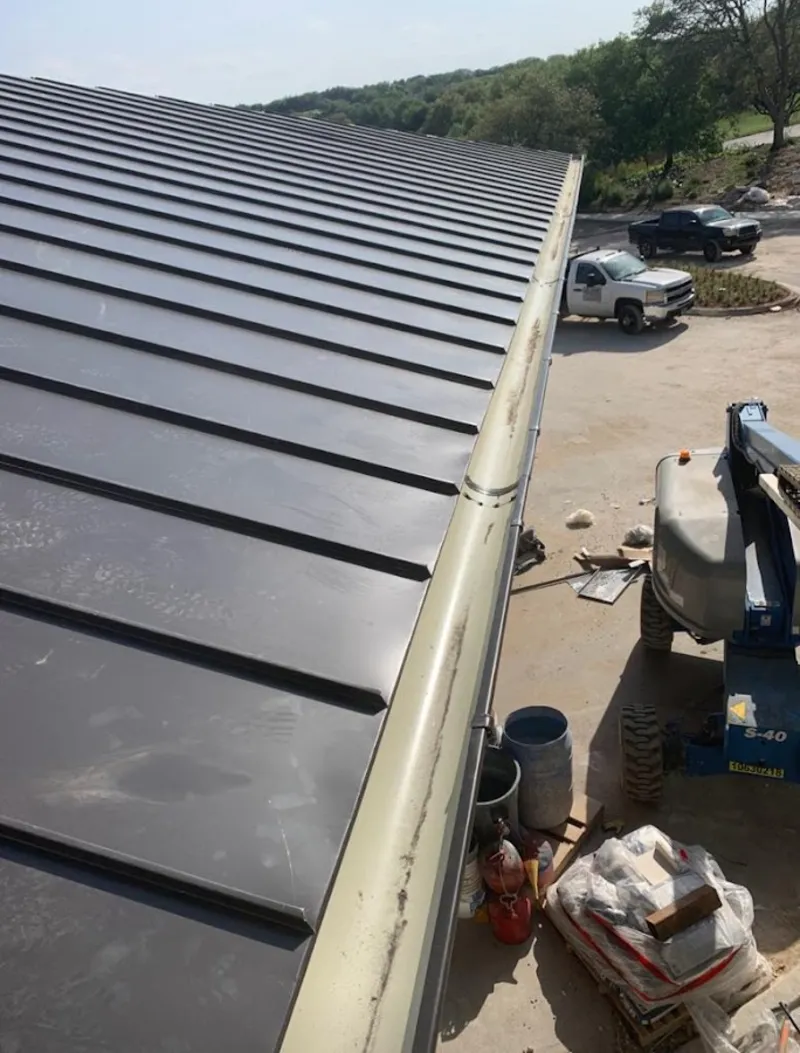 Standing seam panel and gutter detail on a metal roofing jobsite in Jarrell